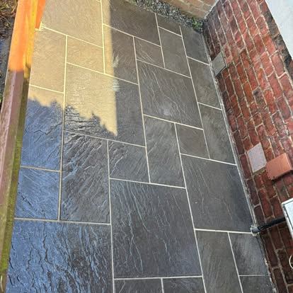 Grey slate-effect patio jet washed to remove algae and grime